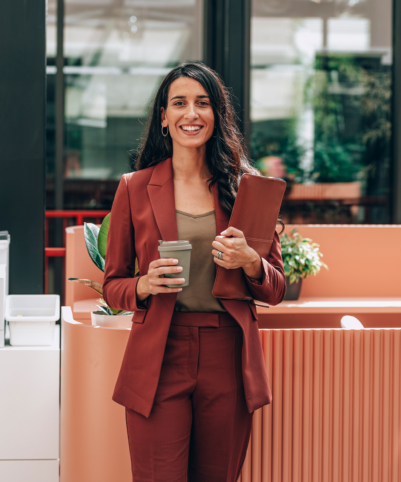 Woman smiling holding a coffee cup in the office